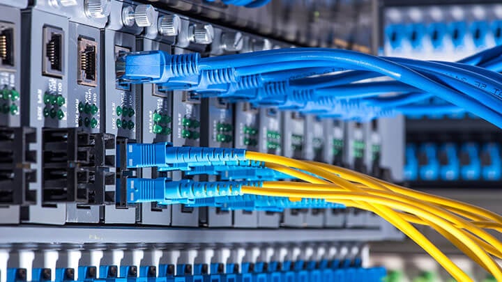 Cables de red azules y amarillos conectados a una interfaz de servidor